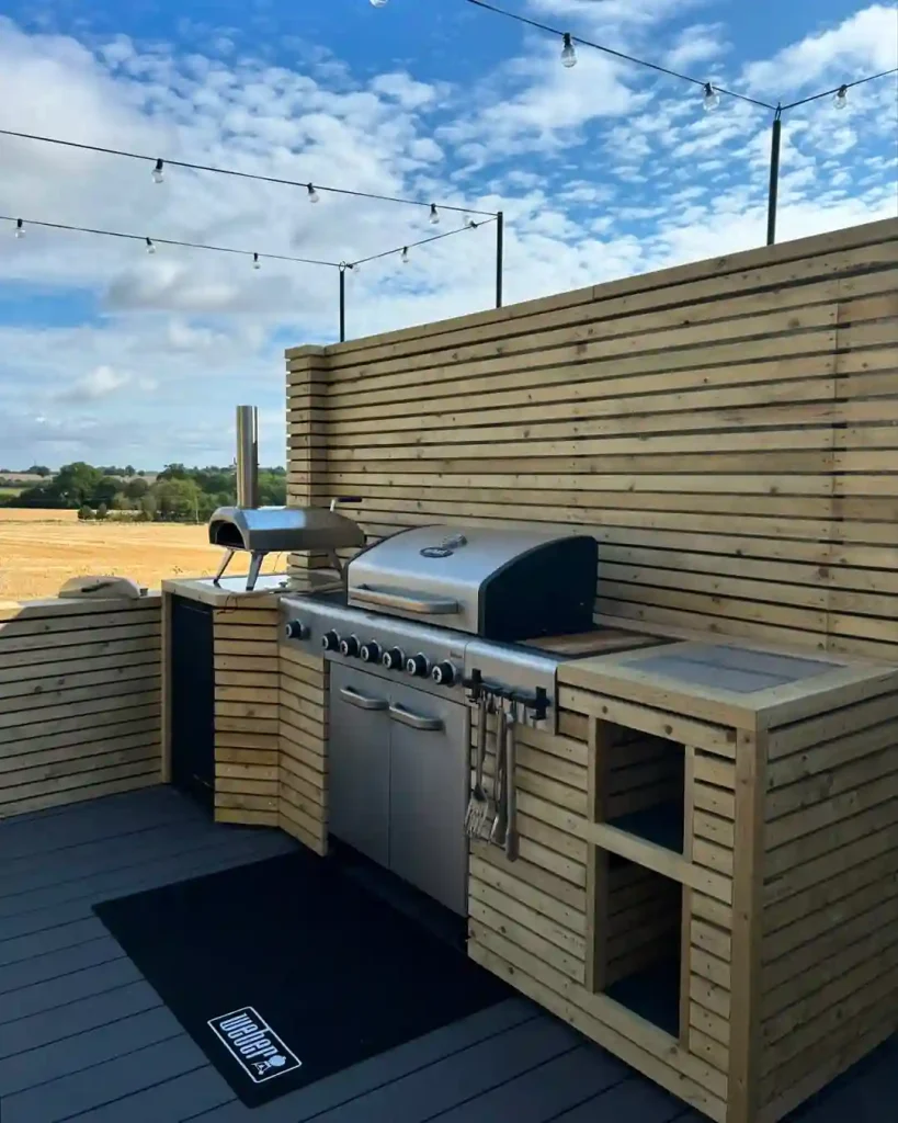 Minimal wood-slat outdoor kitchen with string lights